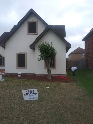 White house exterior with dark trim and gable, freshly painted siding and window frames