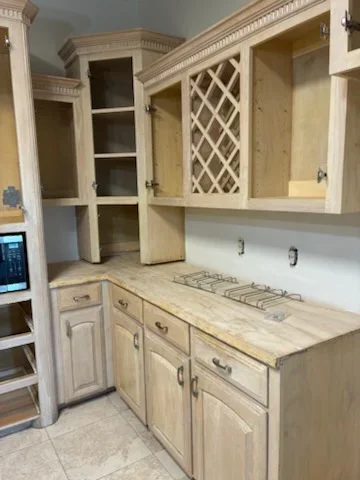 Painted kitchen cabinets, drawers, and crown molding in cream finish with open shelving and hardware
