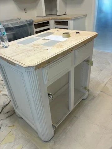 White painted kitchen island with marble countertop during refinishing project