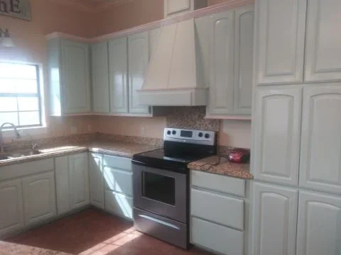 Kitchen with mauve painted ceiling, white painted walls and cabinetry, stainless steel range