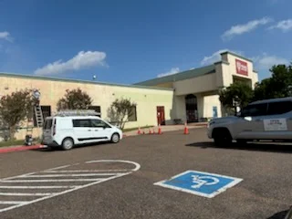 Freshly painted parking lot with white striping, blue handicap symbol, and directional arrows on commercial property