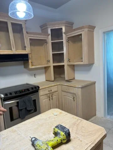 Natural wood stained kitchen cabinets with painted walls and modern pendant lighting