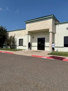 Cream and white painted commercial building exterior with black trim and stucco finish