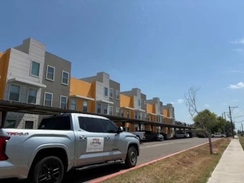 Multi-unit commercial building with gold and tan exterior paint and white trim accents